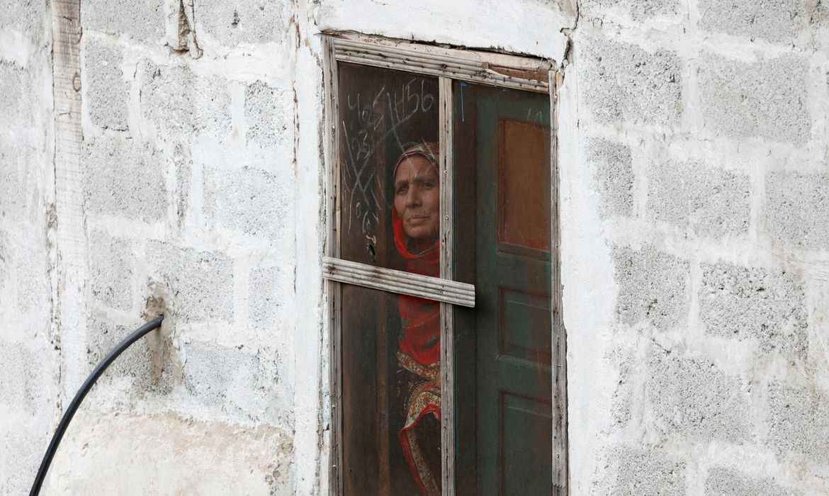 A woman looks out from a window of her home in Chakothi Village on the Line of Control (LoC) in Pakistan-administrated Kashmir, May 2, 2025. Reuters/Akhtar Soomro/Proibida reprodução