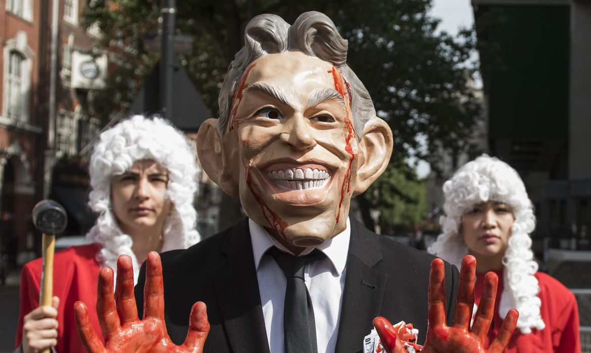 Boneco de Tony Blair com as mãos sujas de sangue desfila em manifestação pelas ruas de Londres, após a divulgação de relatório que acusa o ex-premier de cometer série de erros no conflito contra o Iraque