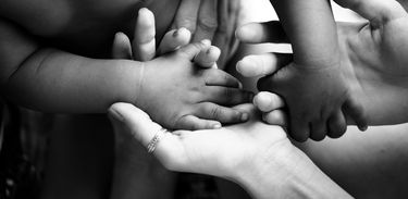 Mãe e bebê adotivo dando as mãos