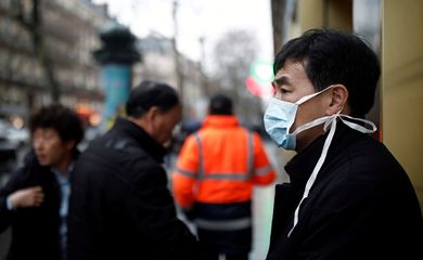 Um turista usa uma máscara protetora em frente à loja de departamentos Galeries Lafayette, em Paris, quando o país é atingido pelo novo coronavírus, na França, em 30 de janeiro de 2020. 