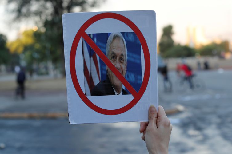 A demonstrator holds up a sign with a picture of Chile's President Sebastian Pinera during a protest against Chile's government at Plaza Italia in Santiago, Chile November 5, 2019. REUTERS/Jorge Silva