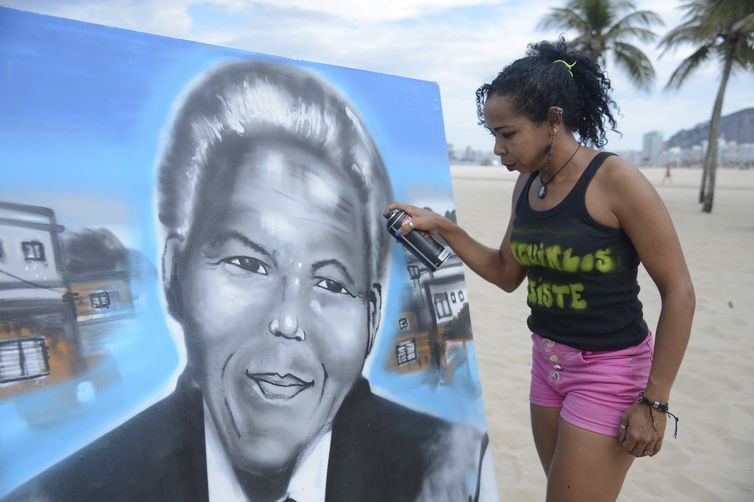 Rio de Janeiro -  A educadora Graciara da Silva, moradora da favela do Mandela, grafita quadro durante almoço pelo Dia das Mães nas areias da praia de Copacabana como forma protesto contra a insegurança nas comunidades onde vivem (Tomaz
