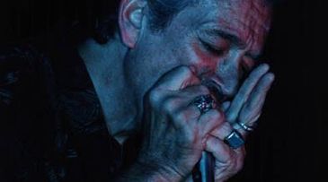 Músico Charlie Musselwhite tocando gaita