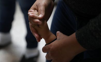 Uma mulher segura a mão de uma criança enquanto famílias de imigrantes ilegais são libertadas da detenção no Texas, nos Estados Unidos 