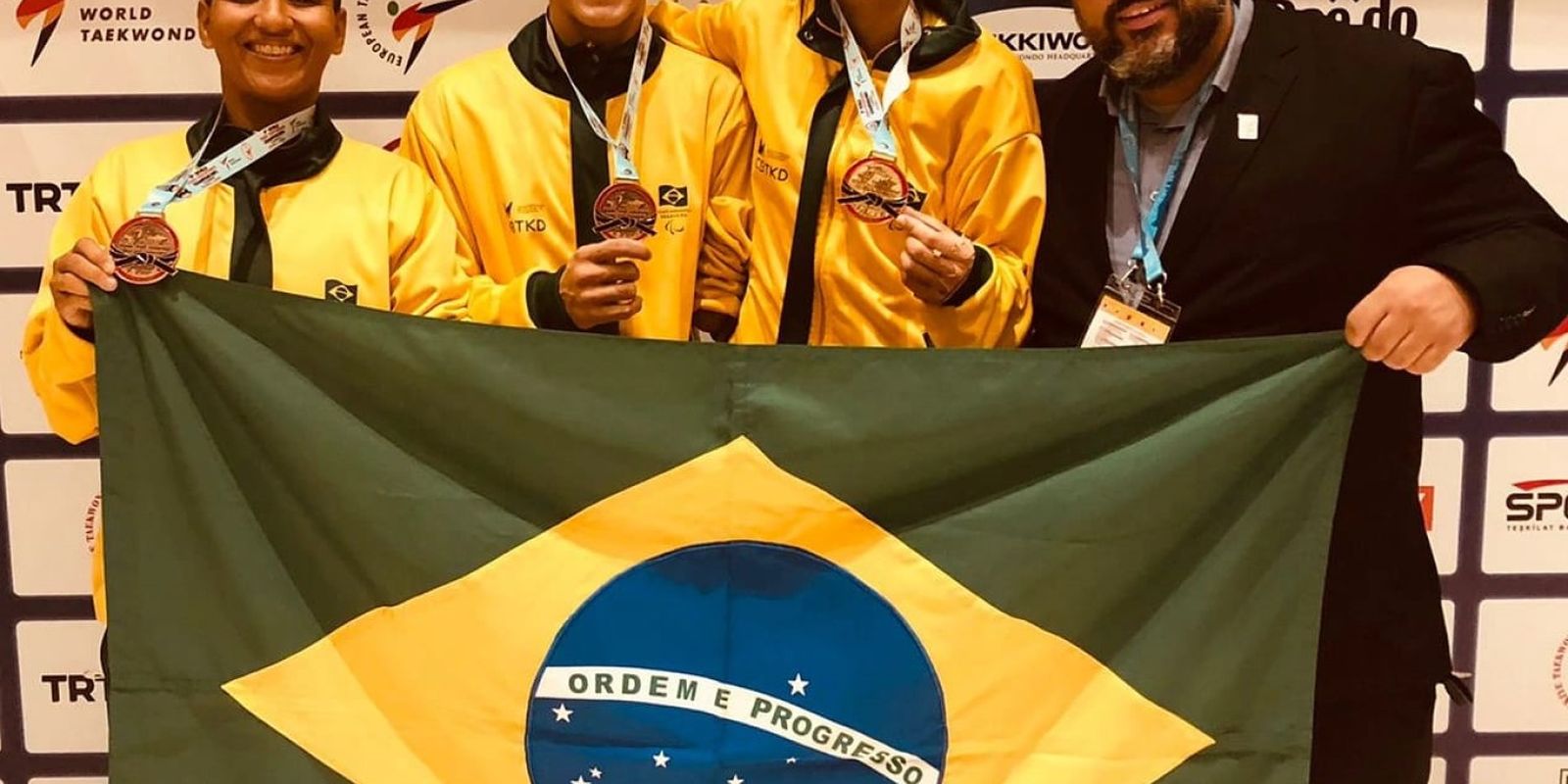 Trio de medalhistas com bandeira