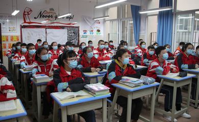 Junior high students wearing face masks attend a class on their first day of returning to school following an outbreak of the novel coronavirus, in Guiyang, Guizhou