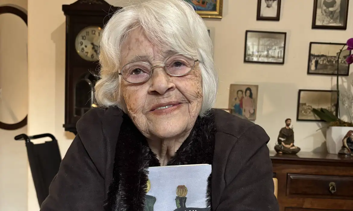 Ana Prado/Arquivo pessoal 28.01.2026 - Foto de arquivo - A poeta Adélia Prado com seu livro 'O Jardim das Oliveiras' em sua casa em Divinópolis. Foto: Ana Prado/Arquivo pessoal