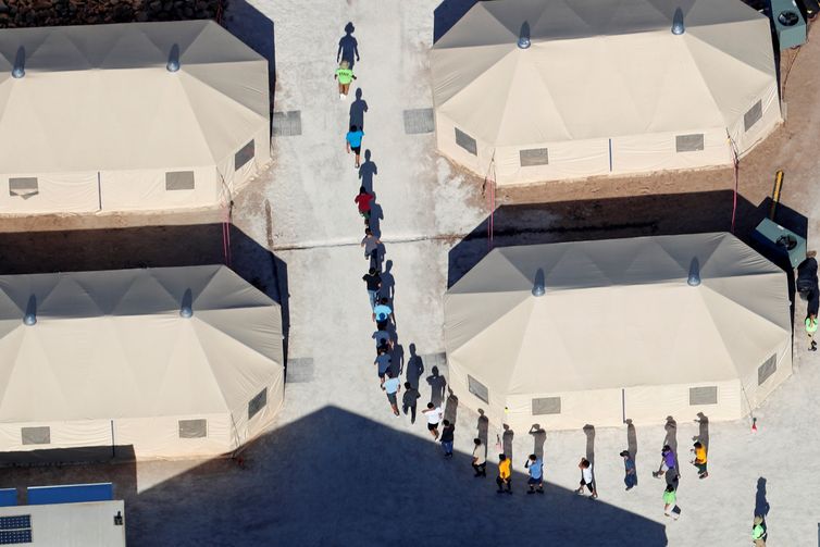 Immigrant children, many of whom have been separated from their parents under a new "zero tolerance" policy by the Trump administration, walk in single file between tents in their compound next to the Mexican border in Tornillo, Texas, U.S. June/Mike Blake/Reuters/direitos reservados Immigrant children, many of whom have been separated from their parents under a new "zero tolerance" policy by the Trump administration, walk in single file between tents in their compound next to the Mexican border in Tornillo, Texas, U.S. June