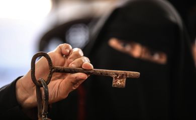 A Palestinian woman holds a key during a demonstration ahead of the 74th anniversary of the Nakba, the 