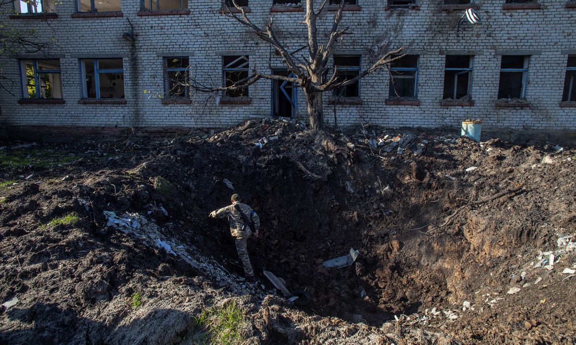 Soldado ucraniano em cratera causada por bomba na cidade de Lyman, no leste da Ucrânia.