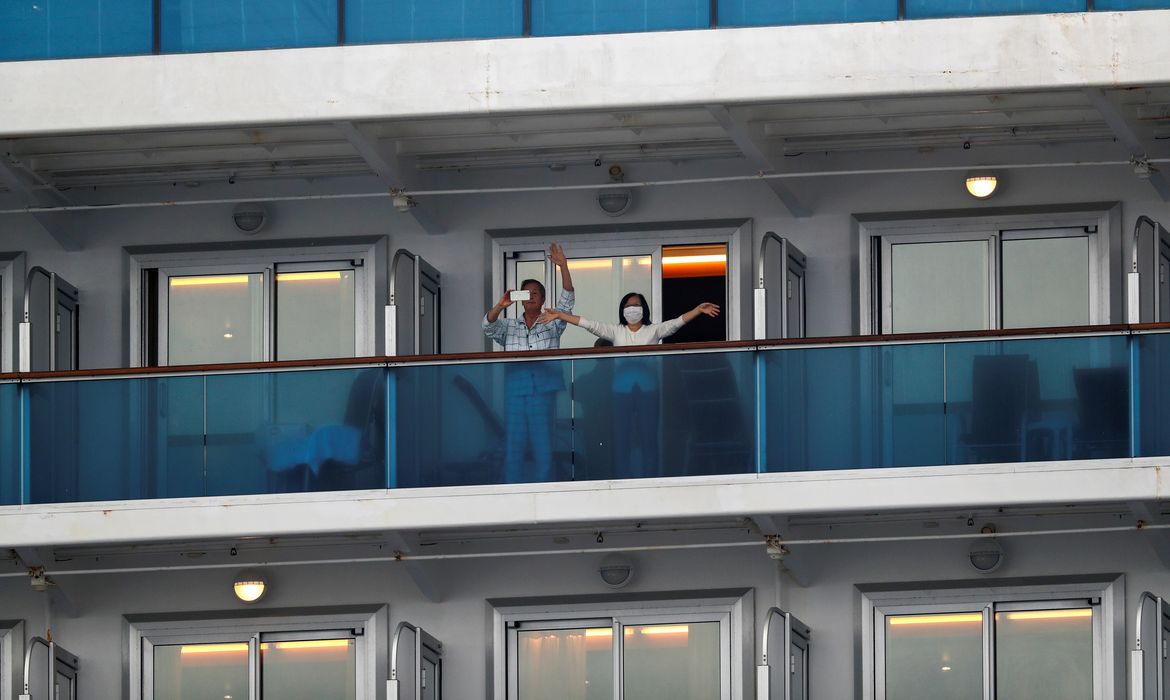 Passengers wave from the cruise ship Diamond Princess in Yokohama