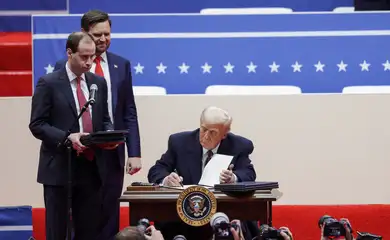U.S. President Donald Trump signs executive orders as U.S. Vice President J.D. Vance looks on during a rally on the inauguration day of his second Presidential term, inside Capital One, in Washington, U.S. January 20, 2025. Reuters/Mike Segar/Proibida reprodução