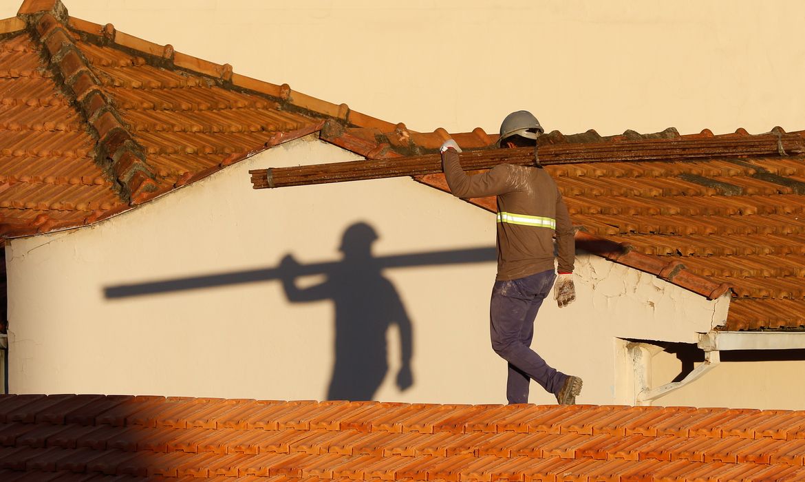 Operários reformam telhado de imóvel em obras no Centro do Rio.