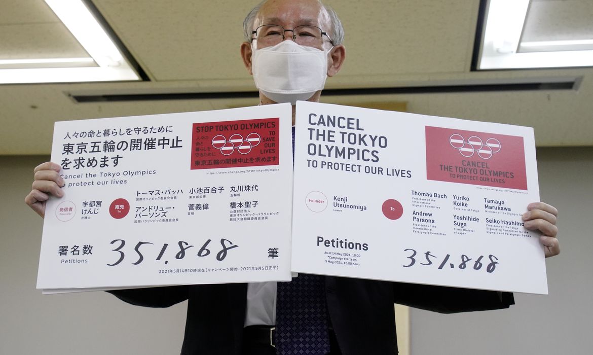 Advogado Kenji Utsunomiya exibe cartazes durante entrevista coletiva após envio de petição solicitando o cancelamento da Olimpíada de Tóquio
