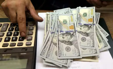 Funcionário de casa de câmbio do Cairo conta notas de dólar
