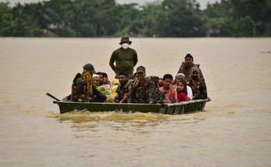 Soldados indianos levam pessoas para local seguro após chuvas pesadas em distrito de Hojai