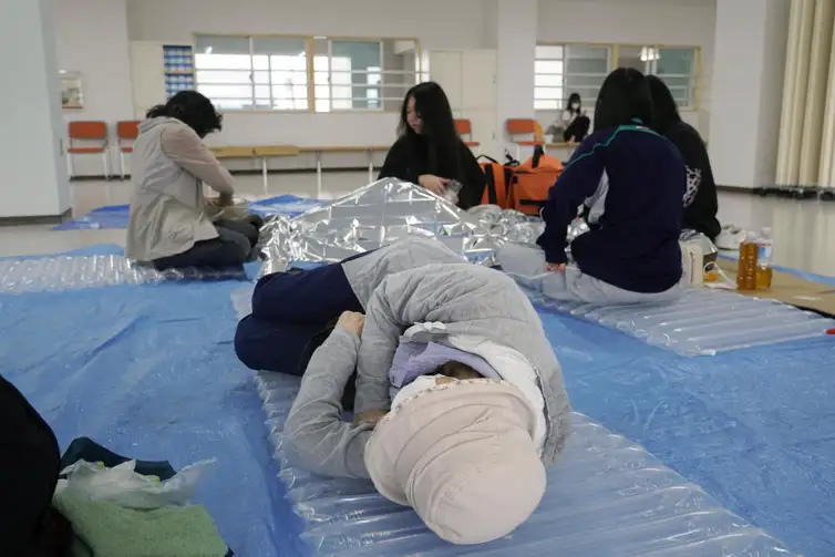 A woman lies down at an evacuation tower in Kushiro, Hokkaido, northern Japan, July 30, 2025, after the Japan Meteorological Agency issued a tsunami warning for the country's Pacific coast following a powerful earthquake off Russia's Kamchatka Peninsula in this photo taken by Kyodo. Mandatory credit Kyodo/via REUTERS ATTENTION EDITORS - THIS IMAGE HAS BEEN SUPPLIED BY A THIRD PARTY. MANDATORY CREDIT. JAPAN OUT. NO COMMERCIAL OR EDITORIAL SALES IN JAPAN.      TPX IMAGES OF THE DAY