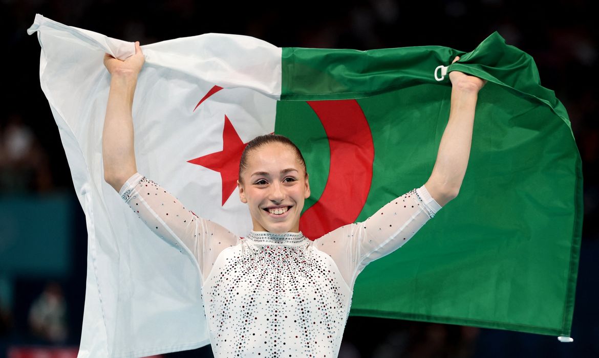 Ginasta argelina Kaylia Nemour posa para foto com a bandeira de seu país após conquistar a medalha de ouro nas barras assimétricas na Olimpíada Paris 2024
04/08/2024 Reuters/Mike Blake/Proibida reprodução