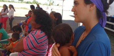 Voluntária com criança venezuelana no Centro de Referência ao Imigrante, em Roraima