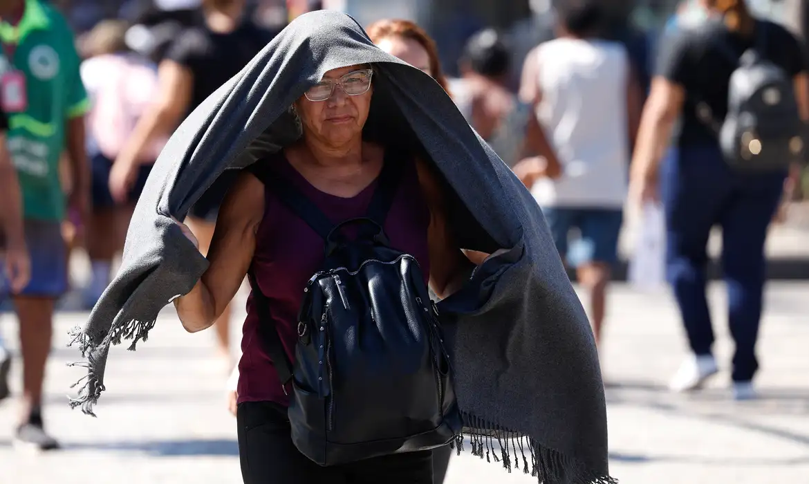 Rio de Janeiro (RJ), 17/02/2024 -Transeuntes se protegem do forte calor nas ruas do centro da cidade. Cidade do Rio de Janeiro atinge nível 4 de calor. Marco é caracterizado por temperaturas que podem chegar a 44ºC  Foto: Tânia Rêgo/Agência Brasil
