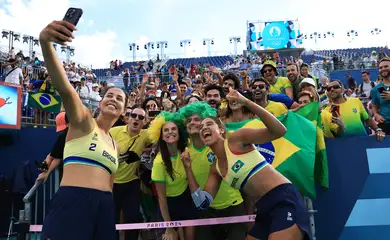 Paris 2024 Olympics - Beach Volleyball - Women's Quarterfinal - Brazil vs Latvia (Ana Patricia/Duda vs Tina/Anastasija) - Eiffel Tower Stadium, Paris, France - August 07, 2024. Ana Patricia Silva Ramos of Brazil and Eduarda Santos Lisboa of Brazil take pictures with fans after winning a match Reuters/Esa Alexander/Proibida reprodução