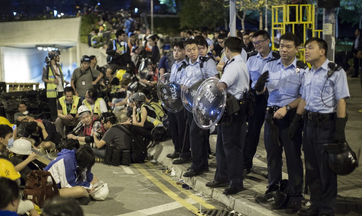 Protestantes pró-democracia e a polícia em confronto na Lung Wo Road