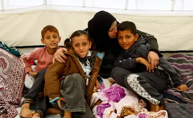 Huda Abu Abed abraça seus netos em um abrigo de tendas após retornar a Gaza pela passagem de Rafah
3 de fevereiro de 2026
REUTERS/Mahmoud Issa