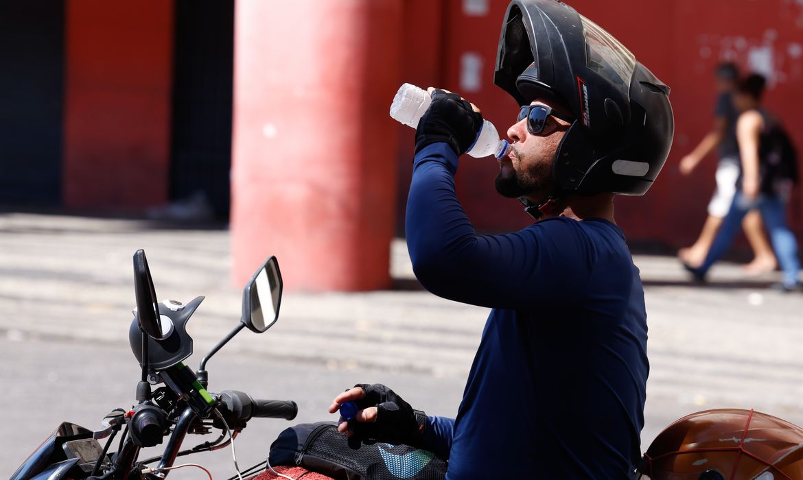 Rio de Janeiro (RJ), 17/02/2024 -Transeuntes se protegem do forte calor nas ruas do centro da cidade. Cidade do Rio de Janeiro atinge nível 4 de calor. Marco é caracterizado por temperaturas que podem chegar a 44ºC  Foto: Tânia Rêgo/Agência Brasil