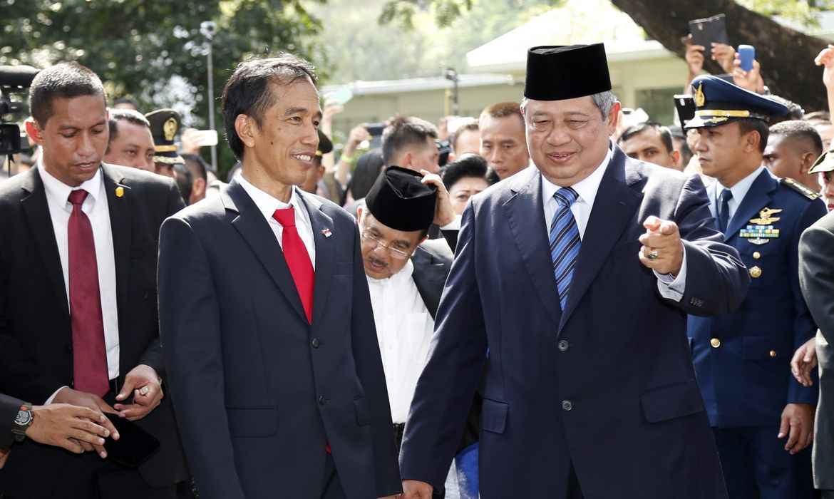 Novo presidente da Indonesia Joko Widodo (à esquerda) é cumprimentado pelo ex-presidente Susilo Bambang Yudhoyono (à direita) em uma cerimônia militar no palácio presidencial, na capital Jacarta