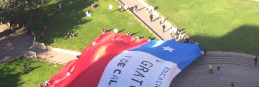 Estudantes chilenos estendem bandeira na Praça da Constituição, exigindo educação pública e de qualidade no Chile