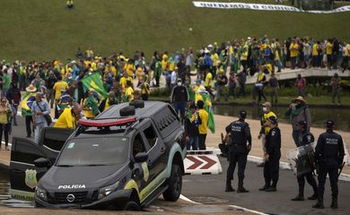 Brasilia (DF) 08/01/2023 - Golpistas invadem prédios públicos na praça dos Três Poderes. Na foto, carros da Polícia Legislativa  são depredados por vândalos em frente ao Congresso Nacional.