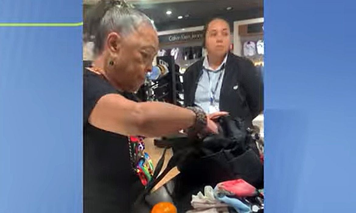 Porta-bandeira da Portela, Vilma Nascimento, é obrigada a esvaziar a bolsa em aeroporto sob suspeita de furto. Imagem: TV Brasil