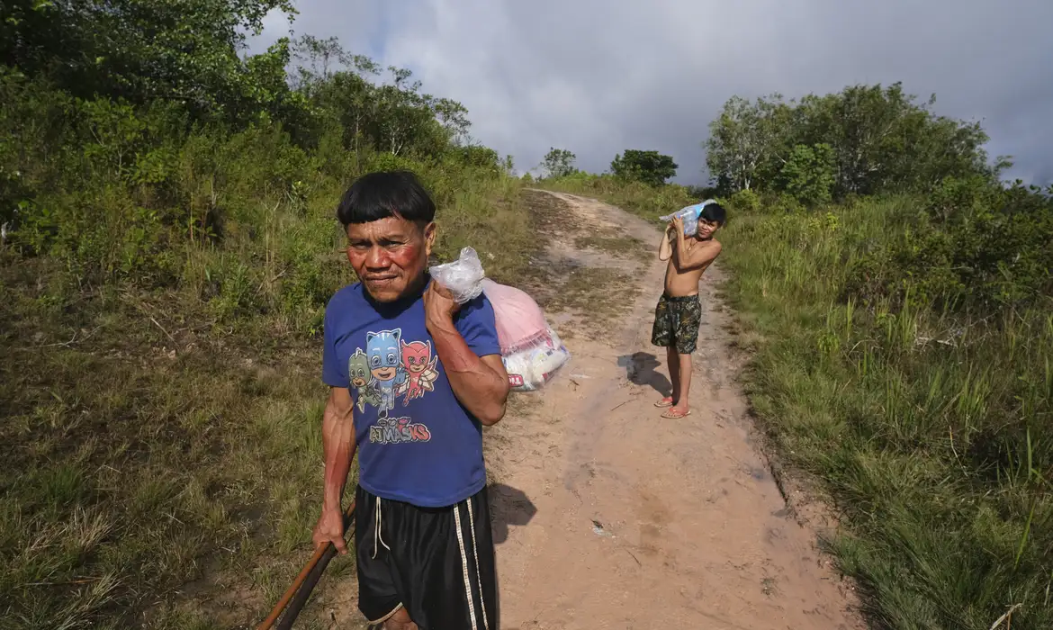 Surucucu (RR), 09/02/2023 - Pedro e Natanael, homens yanomami caminham com suprimentos em trilha no Surucucu, na Terra Indígena Yanomami. Foto: Fernando Frazão/Agência Brasil