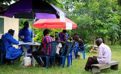 ARCHIV: Ugandische Mitarbeiter des Gesundheitswesens sprechen mit Gemeindemitgliedern, bevor sie die erste Impfung gegen das Ebola-Virus im Dorf Kirembo in Uganda durchführen
