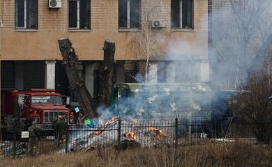 Uniformed people throw items into a fire outside an intelligence building on the premises of the Ukrainian Defence Ministry's unit, in Kyiv