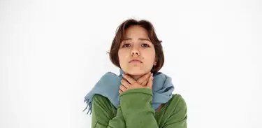 Mulher agasalhada toca a garganta