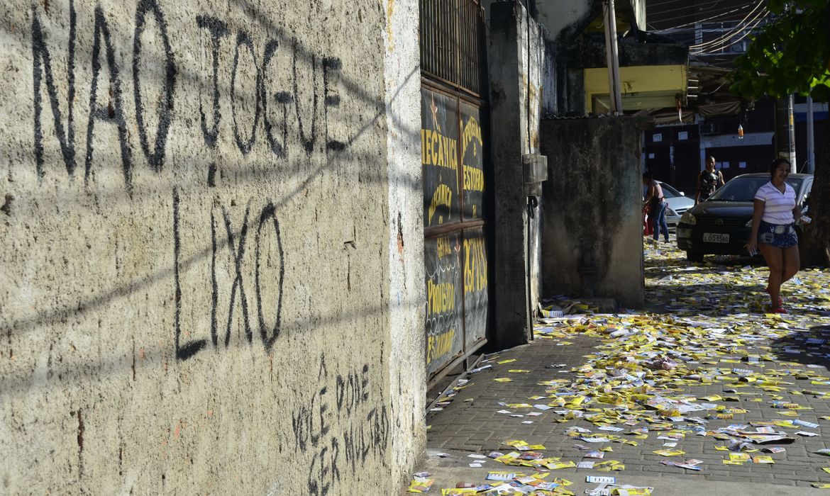 Santinhos com propaganda de candidatos das eleições 2014 acumulados no chão sujam ruas próximas a zonas eleitorais da cidade de Duque de Caxias, na Baixada Fluminense (Fernando Frazão/Agência Brasil)