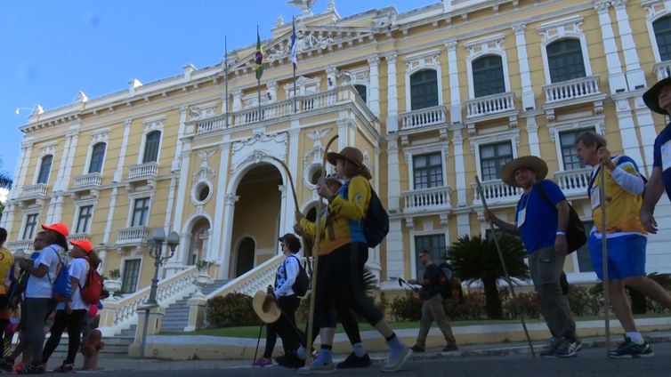 Peregrinos caminham em frente ao Palácio Anchieta