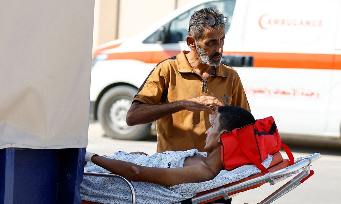 Um homem está ao lado de um palestino ferido, que receberá tratamento em um hospital egípcio, no posto fronteiriço de Rafah com o Egito, no sul da Faixa de Gaza, em 1º de novembro de 2023. REUTERS/Ibraheem Abu Mustafa TPX IMAGENS DO DIA