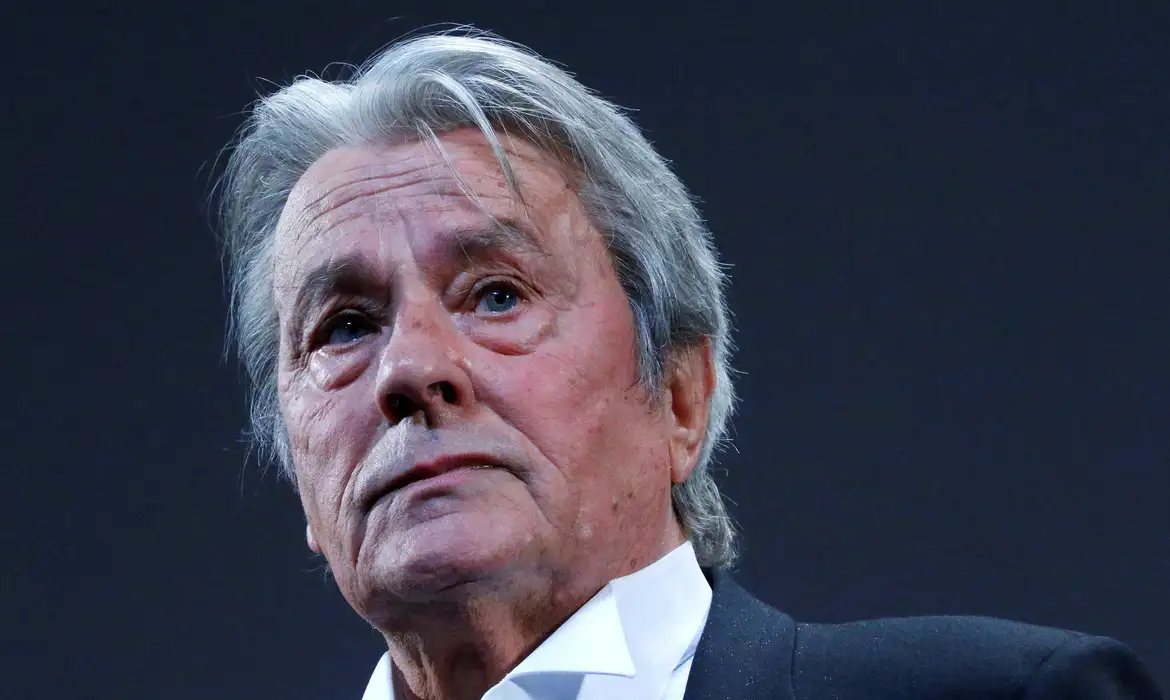 FILE PHOTO: Actor Alain Delon salutes on stage during a tribute for his career before the screening of the restored print of the film 