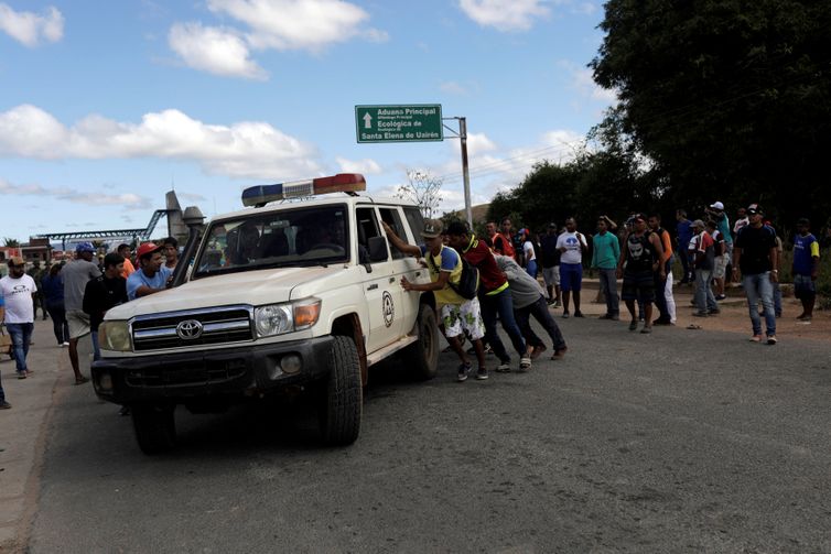 Ambulância que transportava pessoas feridas durante confrontos no sul da cidade venezuelana de Kumarakapay, perto da fronteira com o Brasil, é assistida por pessoas na fronteira entre a Venezuela e o Brasil, em Pacaraima.