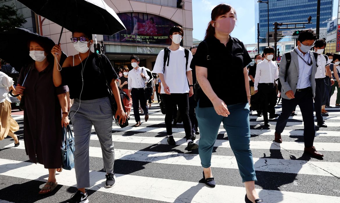 Pessoas usando máscaras de proteção caminham em Tóquio - transeuntes, pedestres- covid-19 - pandemia