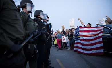 Manifestantes contrários a Donald Trump são separados por uma fileira de policiais dos apoiadores do candidato republicano em um protesto em Costa Mesa, na California