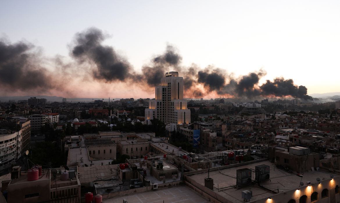 Síria- 08/12/2024  Pessoas passam  por um tanque que pertencia ao Exército Sírio, depois que rebeldes sírios anunciaram que derrubaram Bashar al-Assad da Síria, em Damasco, Síria, 8 de dezembro de 2024. Reuters/Mohamed Azakir/Proibida reprodução