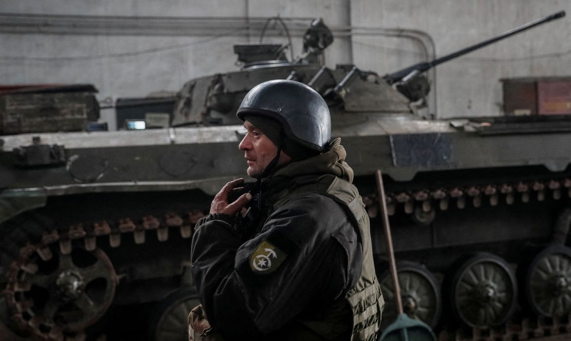 Membro do serviço ucraniano fica perto de um veículo de combate de infantaria na linha de frente perto da cidade de Novoluhanske