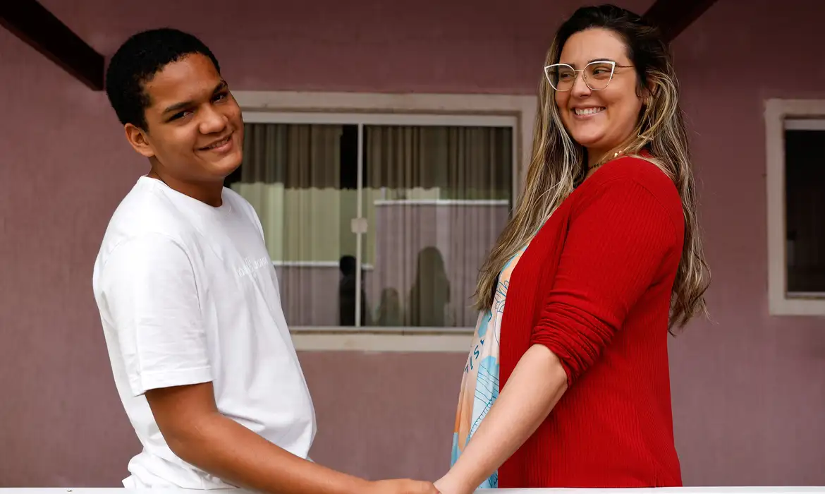 Tânia Rêgo/Agência Brasil Rio de Janeiro (RJ), 25/10/2024 - Bruna Campos e seu filho Thalyson Barbosa, adotado aos 13 anos, em sua casa em Campo Grande, zona oeste da cidade. Foto: Tânia Rêgo/Agência Brasil