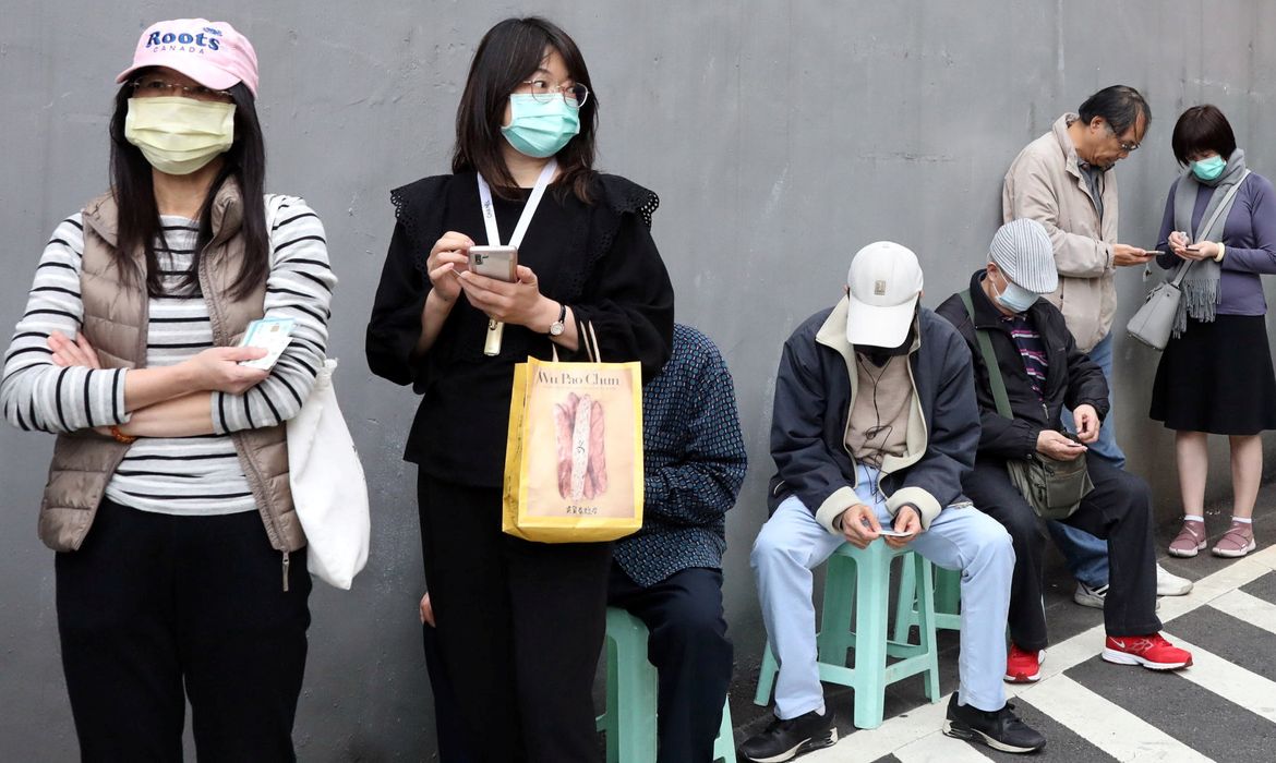 People wait in long lines to buy face masks in order to protect themselves from the coronavirus disease (COVID-19), outside a pharmacy in Taipei