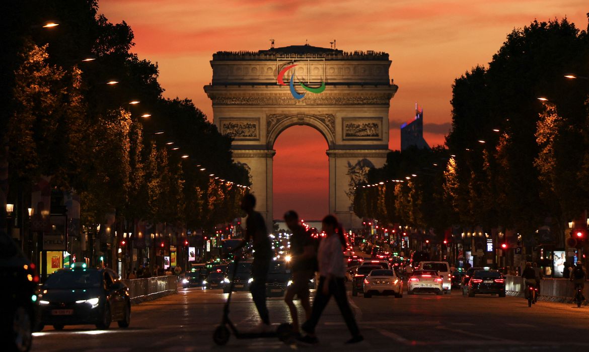 A general view of Avenue des Champs-Elysees and the Arc de Triomphe adorned with the Paris 2024 Paralympic Games logo at sunset, in Paris, France July 31, 2024. REUTERS/Tingshu Wang