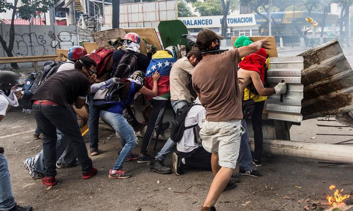 Manifestantes de oposição enfrentam a Guarda Nacional Bolivariana nos protestos da greve geral de 20 de julho de 2017 em Caracas, Venezuela.
