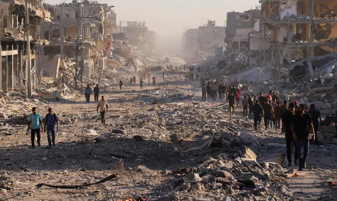 Palestinos caminham em meio a destroços na Cidade de Gaza
 10/10/2025   REUTERS/ Ebrahim Hajjaj